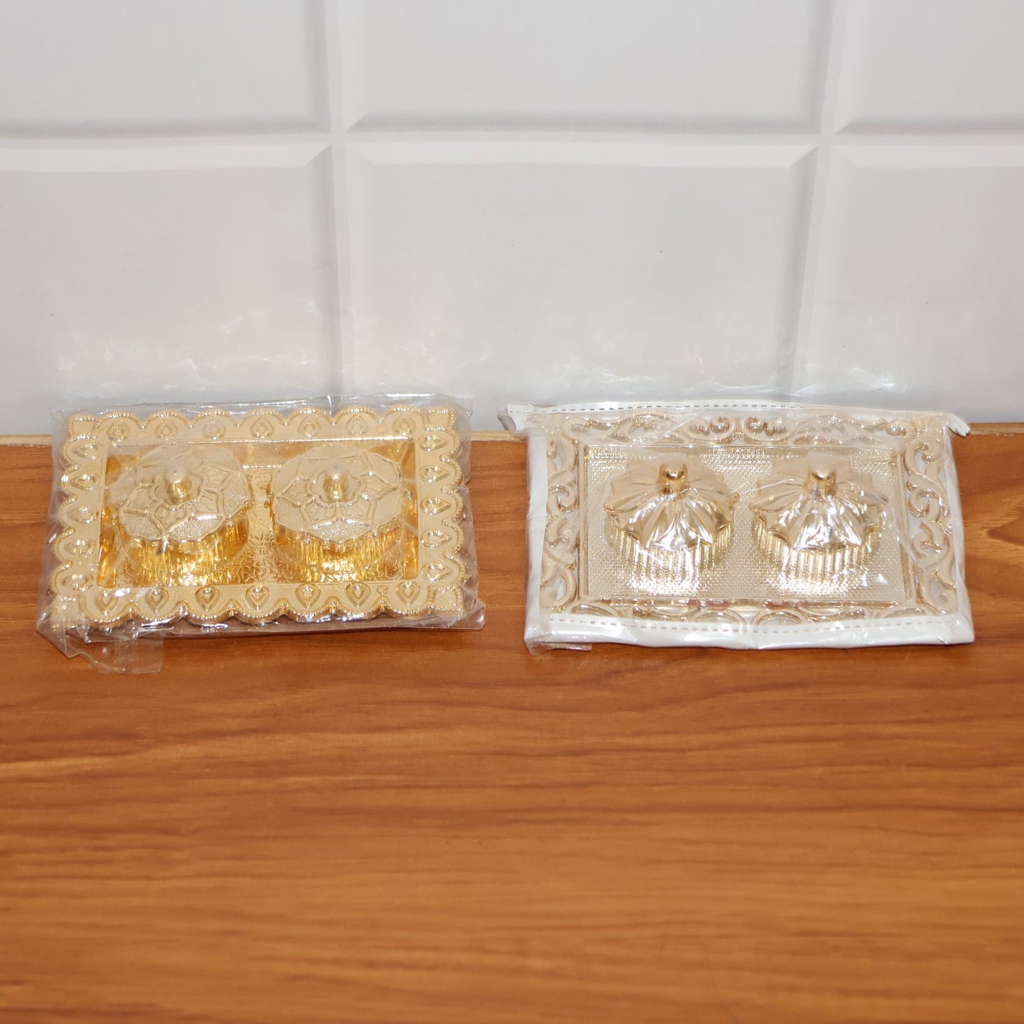 Hands holding the ornate rectangular pooja thali with flower-lid kumkum box