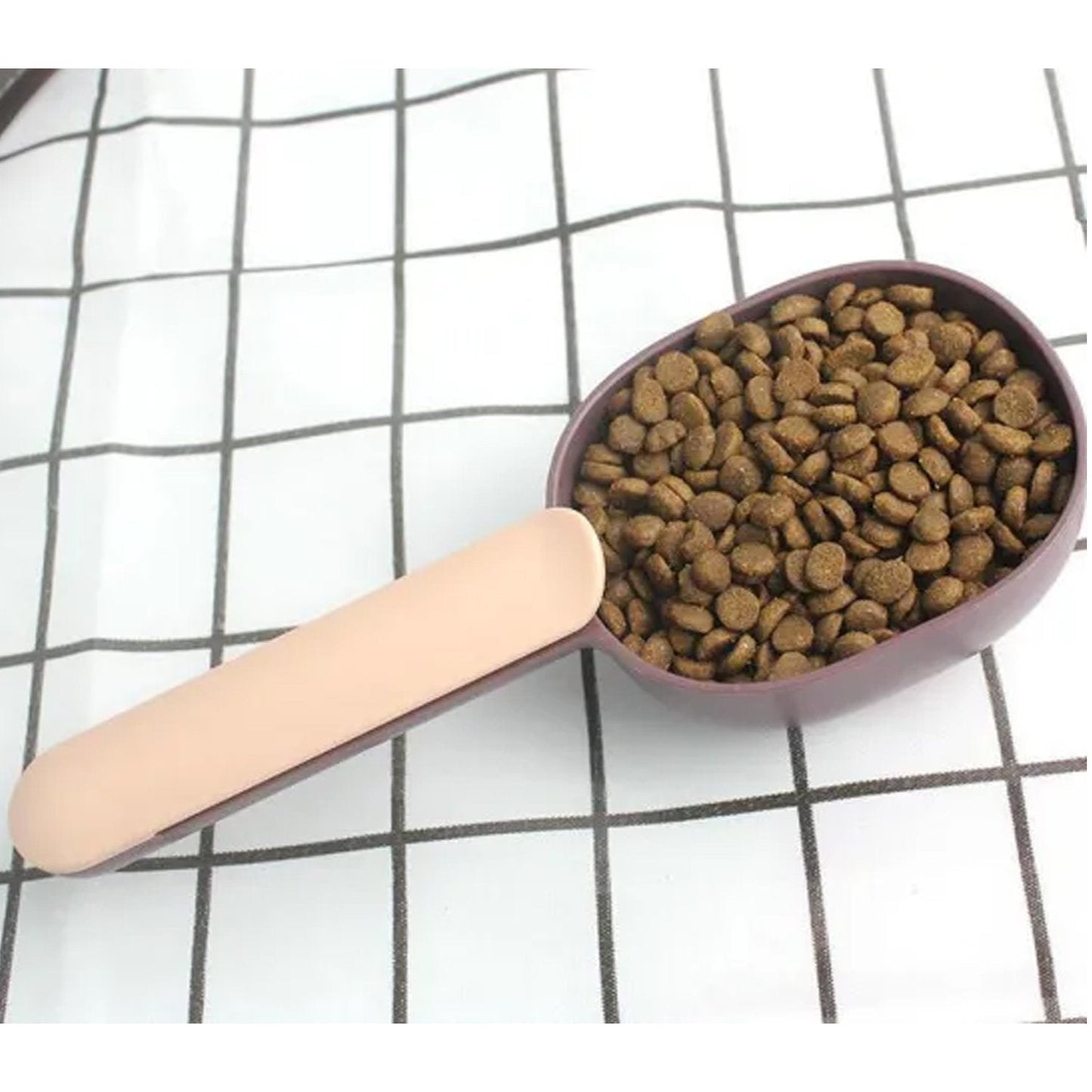 Compact pet food scoop with integrated bag clip for convenient storage.