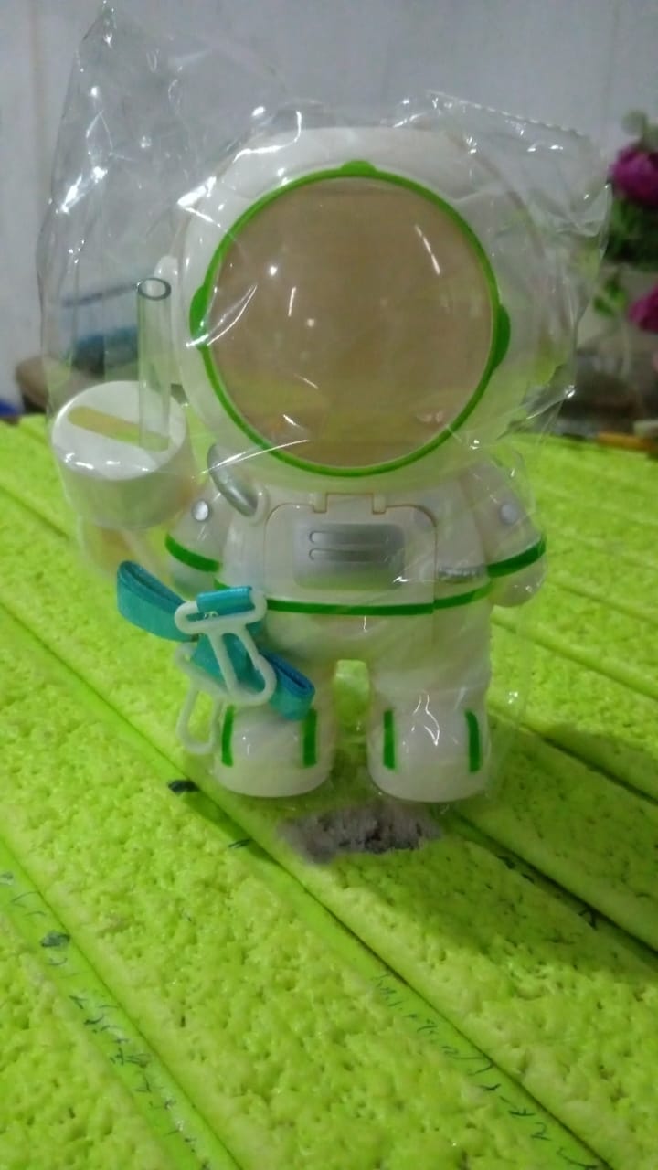 A child holding the lightweight kids astronaut water bottle with its shoulder strap.