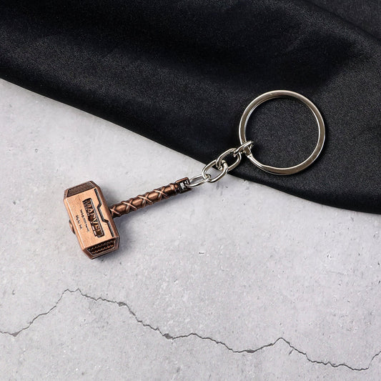Metal Hammer Keychain with antique bronze finish on neutral background