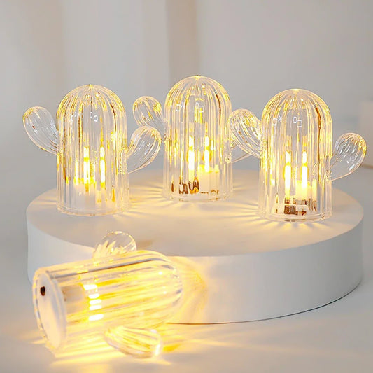 A set of four glowing Cactus LED Night Lights arranged on a wooden surface, casting a warm glow.