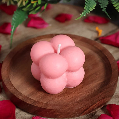 Close-up of flame-lit bubble cube candle casting warm, cozy glow at home