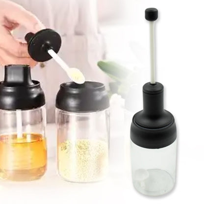 The transparent glass body of the spice container, showing its contents clearly.