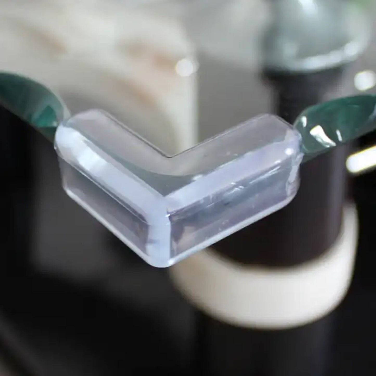 Detailed view of a silicone corner protector securely fitted on a dark desk edge.