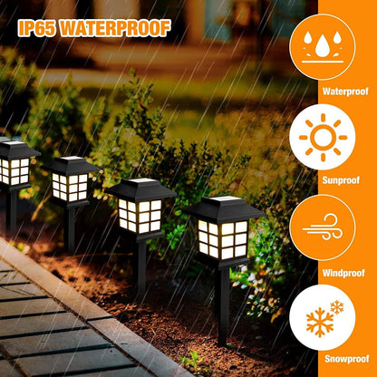 Two solar pathway lights installed along a garden path, casting warm light.