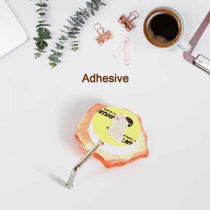 A self adhesive hook securely holding kitchen utensils, demonstrating its utility.
