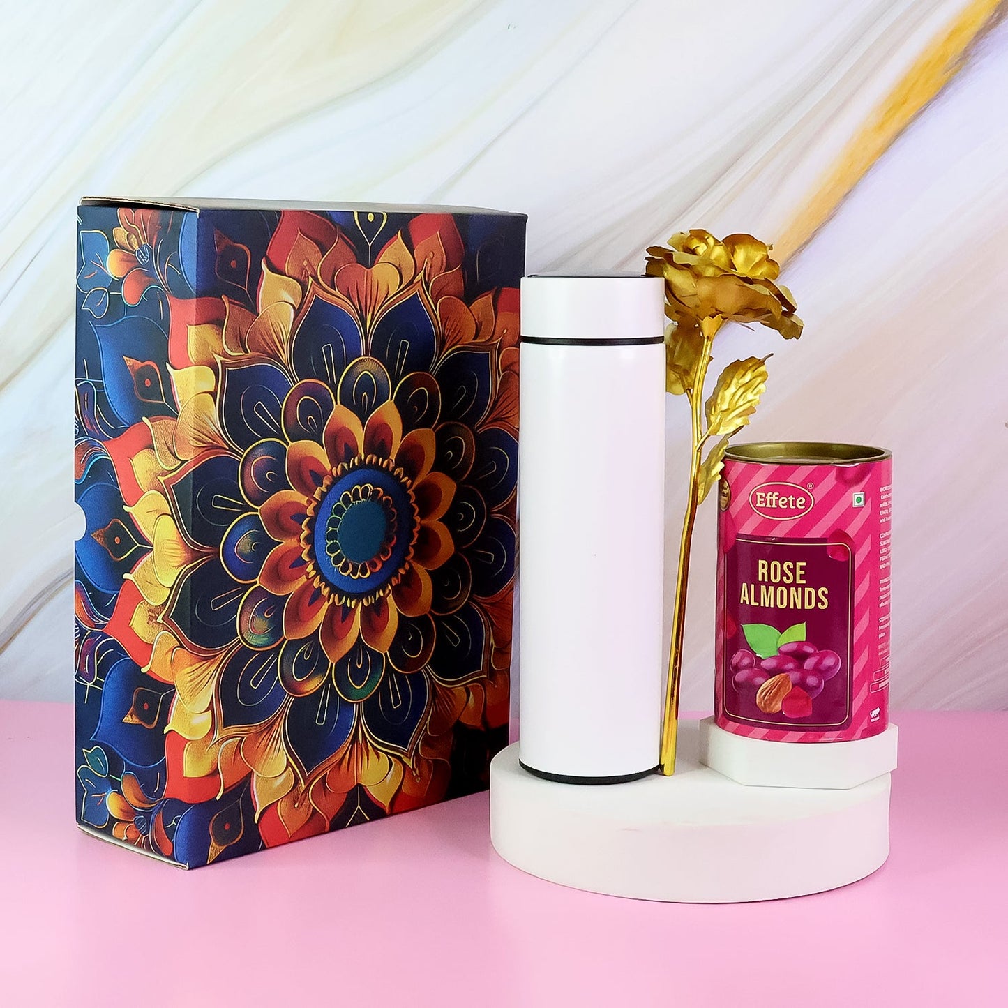 Close-up of almond chocolate diwali hamper with golden rose and stainless steel bottle