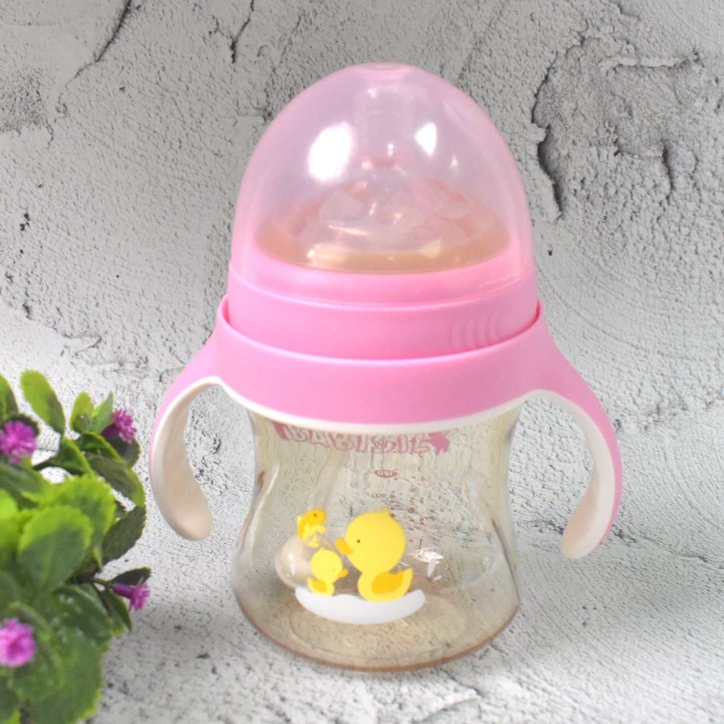 A toddler comfortably holding the Feedora baby feeding bottle with handles.