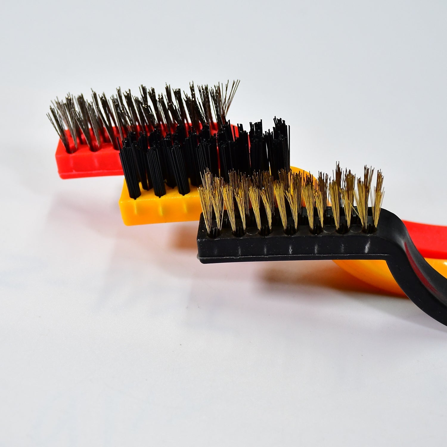 A person using the nylon mini wire brush to clean delicate areas without scratching.