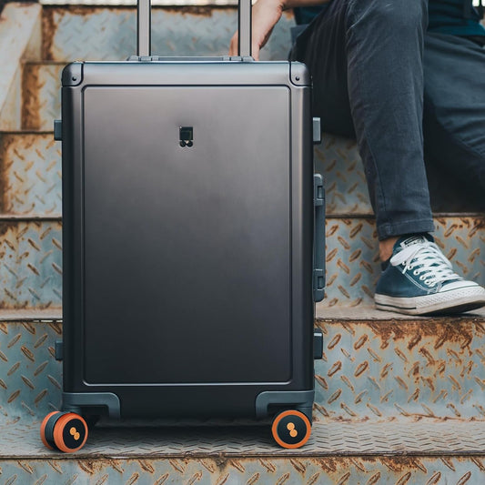 Set of four flexible silicone suitcase wheel covers in black, neatly packaged.