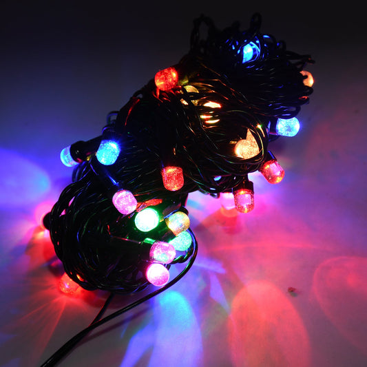Close-up of multi-color flower LED string lights illuminating a festive scene.