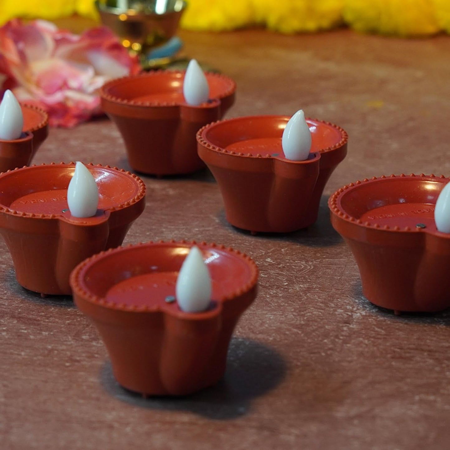 Hand pouring water into a water sensor diya, showing it light up.