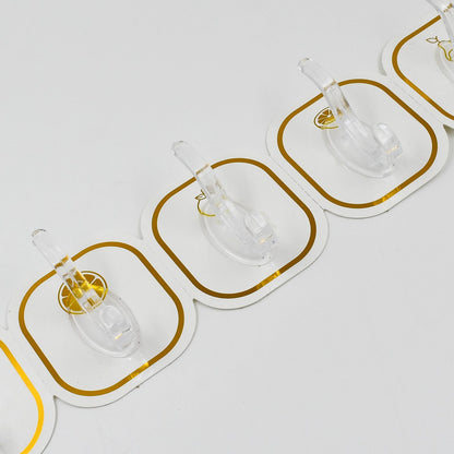 Transparent adhesive hooks installed on a white wall, blending seamlessly with home decor.