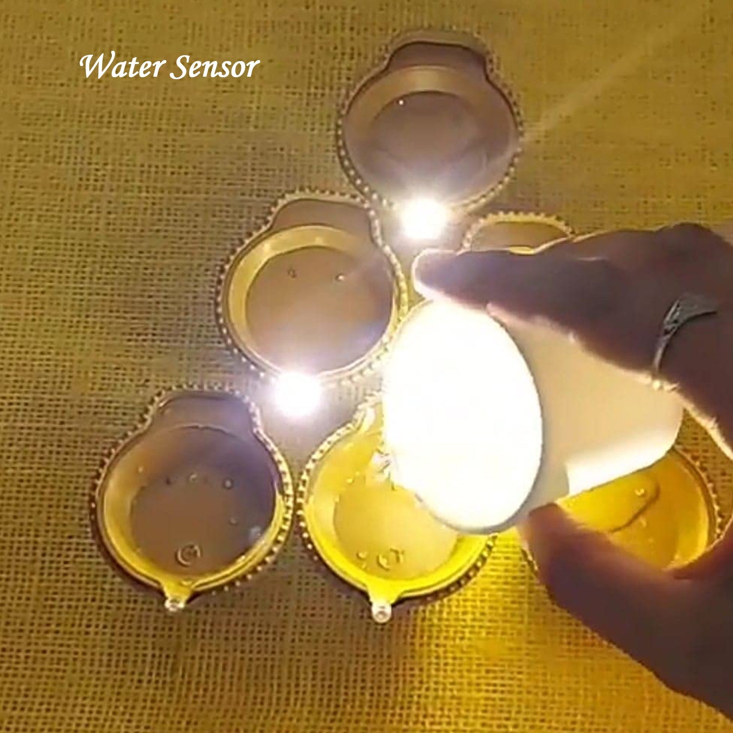 Overhead shot of water sensor diyas illuminating a patterned floor.