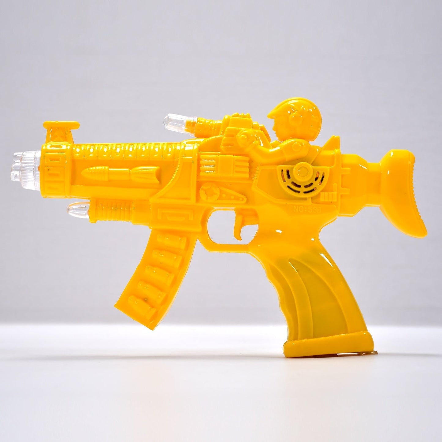 Top-down view of the transparent musical toy gun with glowing internal gears.
