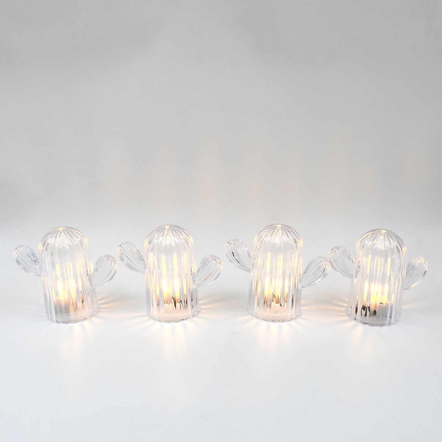 A hand holding a glowing cactus night light, demonstrating its portable and lightweight design.