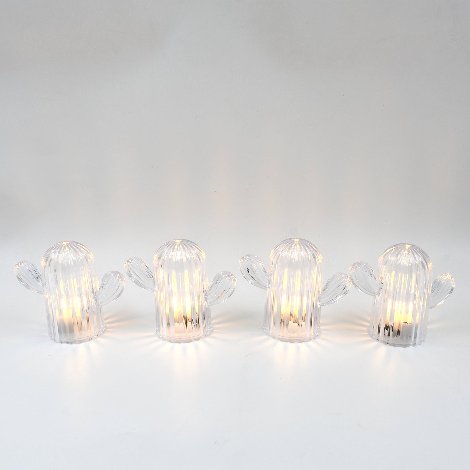 A hand holding a glowing cactus night light, demonstrating its portable and lightweight design.