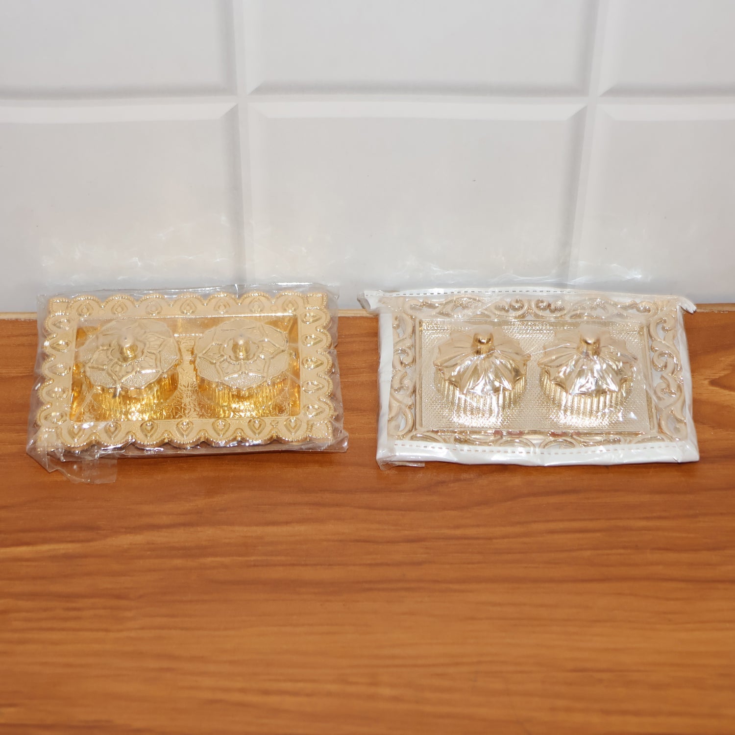 Hands holding the ornate rectangular pooja thali with flower-lid kumkum box