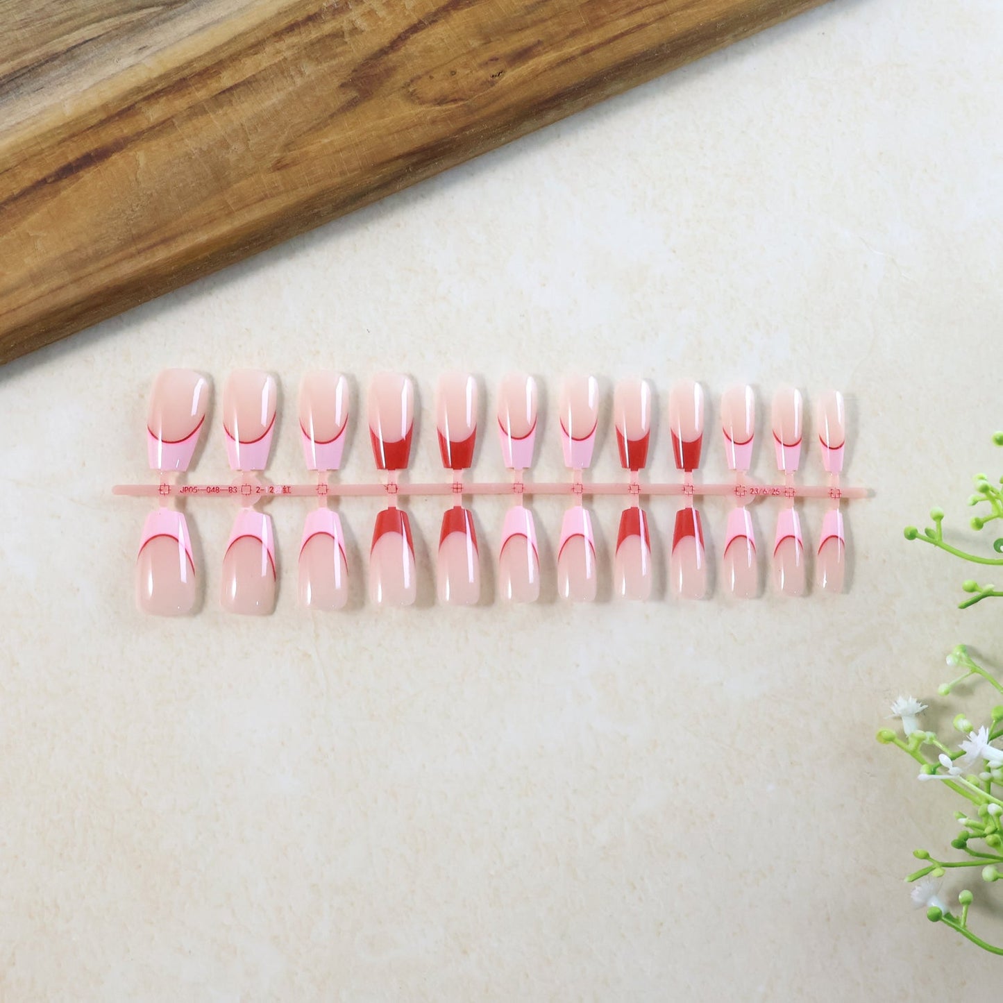 Full set of nude fake nails displayed for manicure use