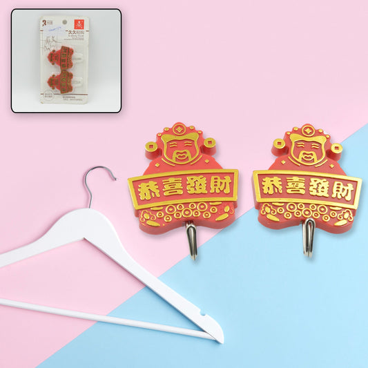 A pair of white self-adhesive hooks displayed on a clean wall.