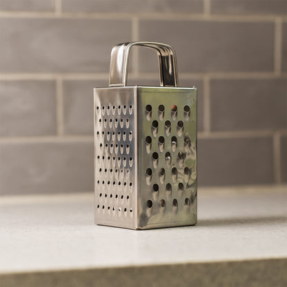 Close-up of multi-sided stainless steel grater and slicer tool