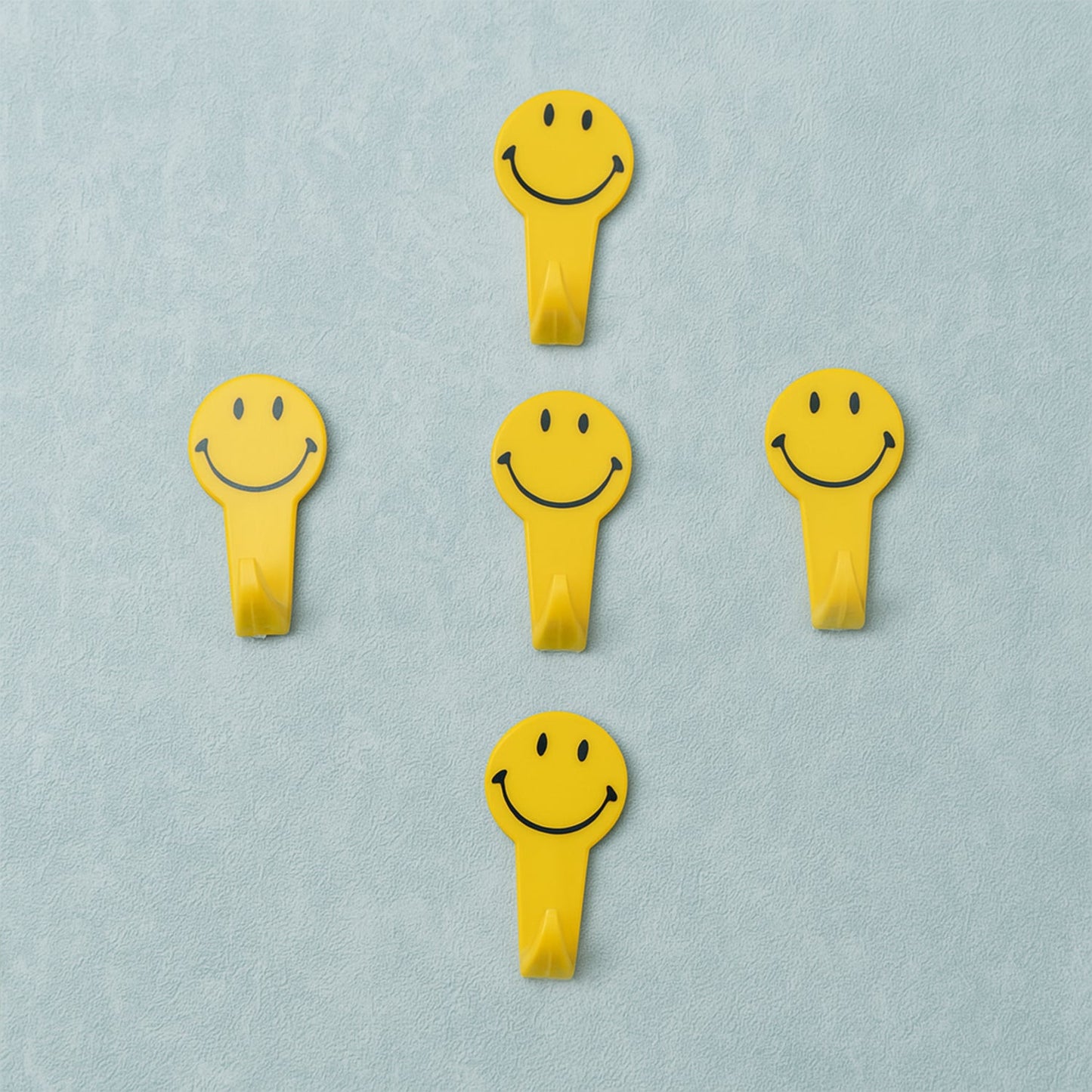 A set of five white self adhesive hooks displayed on a clean surface.