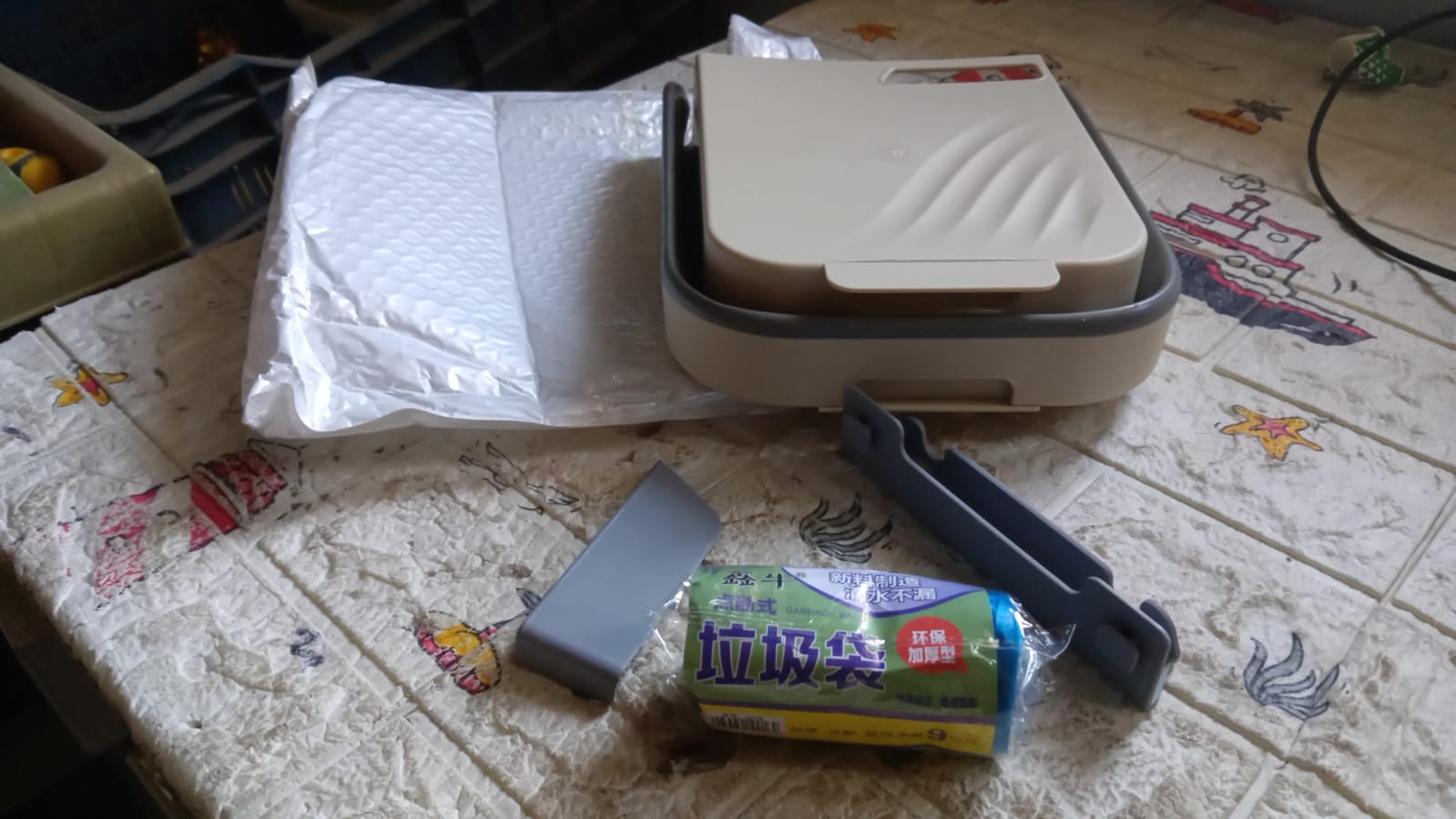 The foldable hanging trash can standing independently on a countertop.