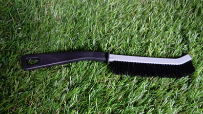Crevice cleaning brush in action, reaching tight spaces under a faucet.