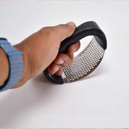 Sturdy stainless steel garlic crusher positioned to highlight its robust construction and ease of use.