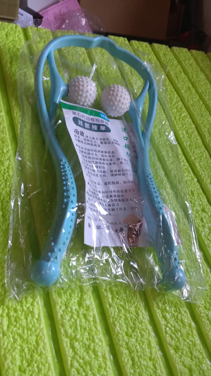 Portable massager wrapped comfortably around a user's neck, showcasing its secure fit.