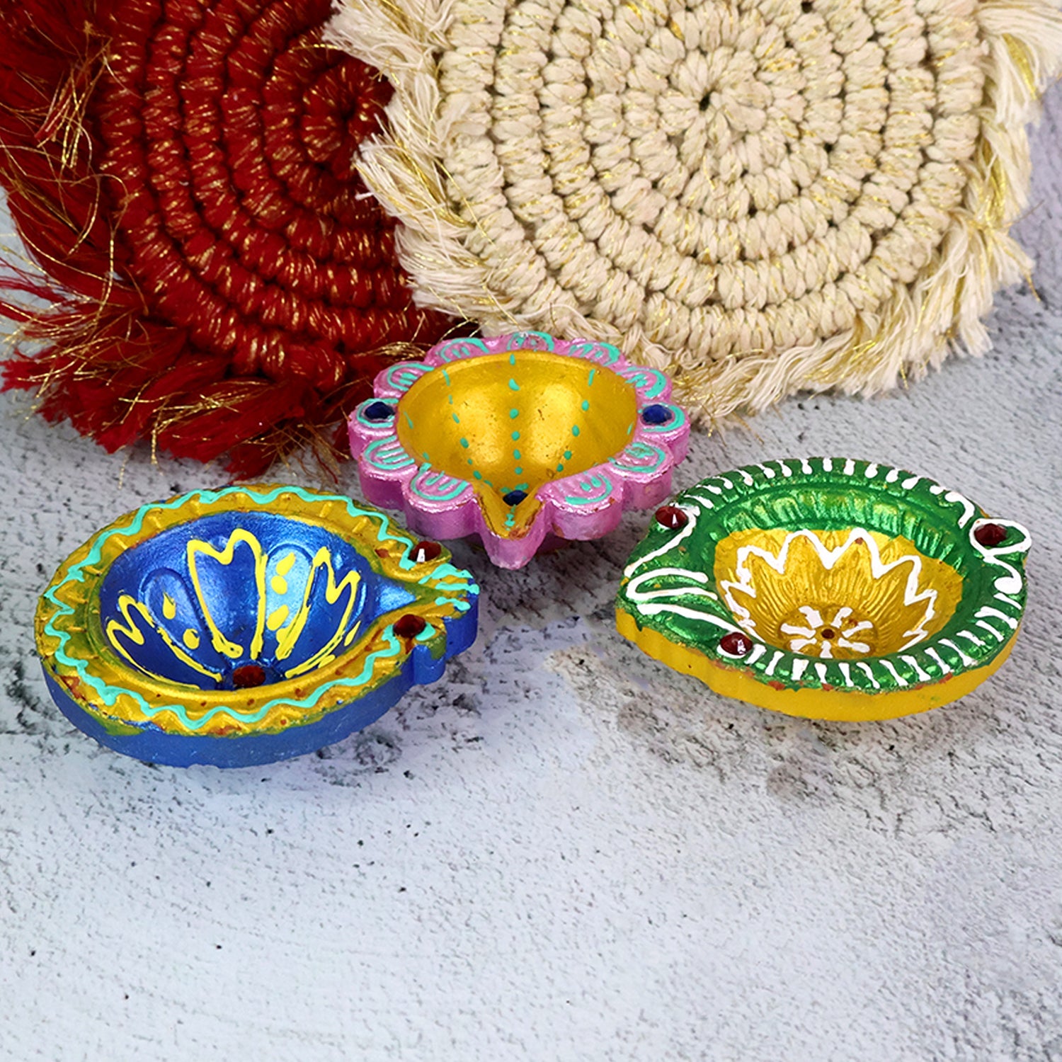 Artistic hand-painted clay diya with vibrant red and yellow colors