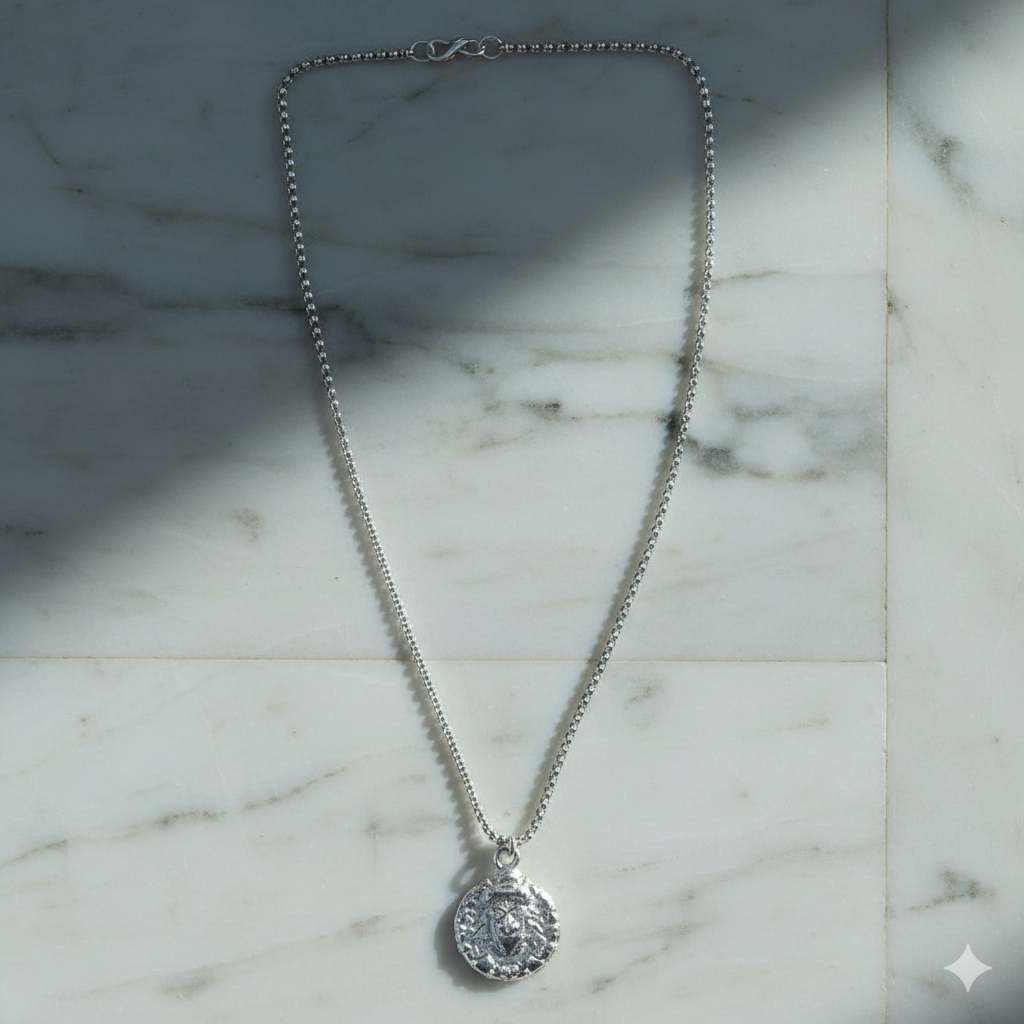 Silver-tone Hanuman Locket Necklace and chain neatly arranged on a flat surface.