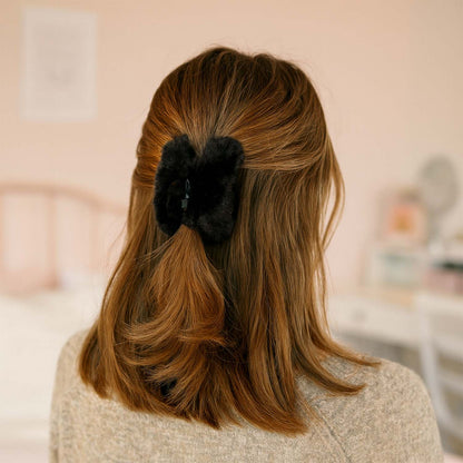 Close-up of soft faux fur hair claw clip showing sturdy plastic base and plush finish.