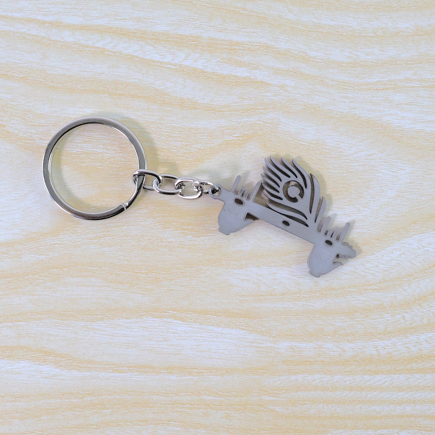 Elegant Krishna Flute Keychain featuring a peacock feather, hanging gracefully.