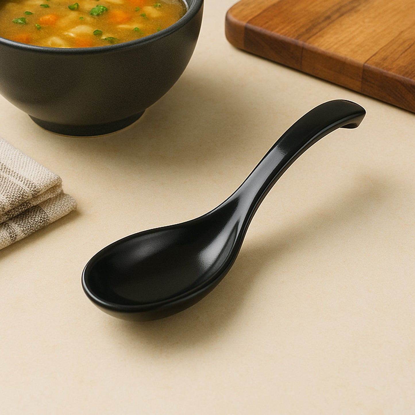 Black plastic soup spoon with curved ergonomic handle for comfortable grip