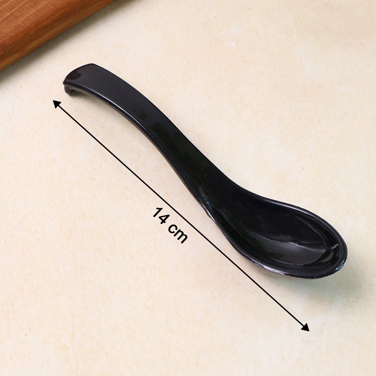 Detailed view of the ergonomic handle of the black plastic soup spoon