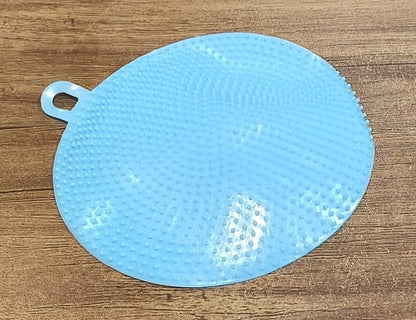 Kitchen setting featuring blue silicone dish scrubber for cleaning
