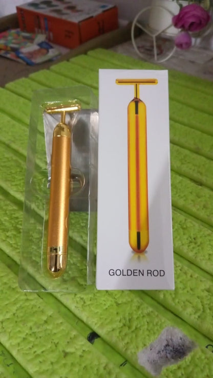 Vibrating facial massage tool in gold finish for skin rejuvenation.